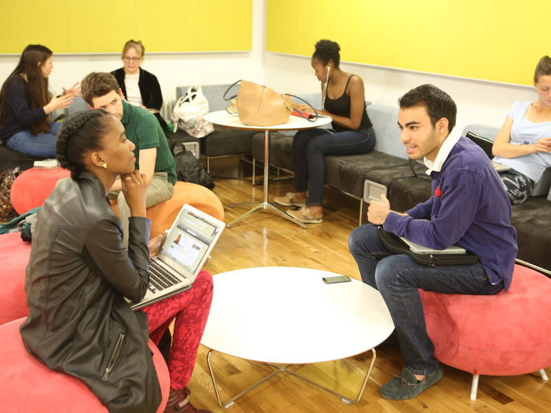 Students chatting in the breakout space on the lower ground floor of 32 Lincon's Inn Fields